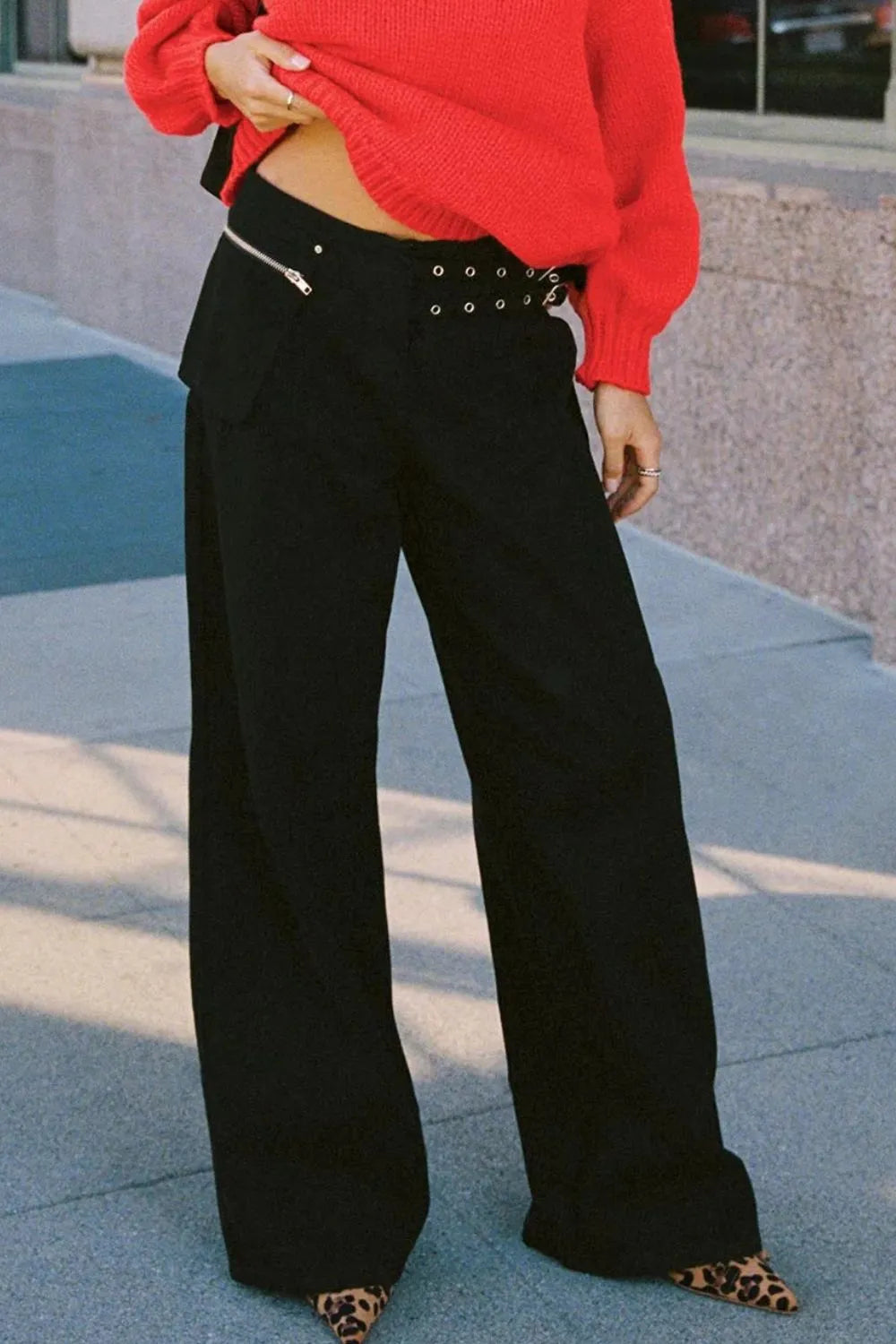 Black wide-leg jeans with pockets and studded belt strap at the waist